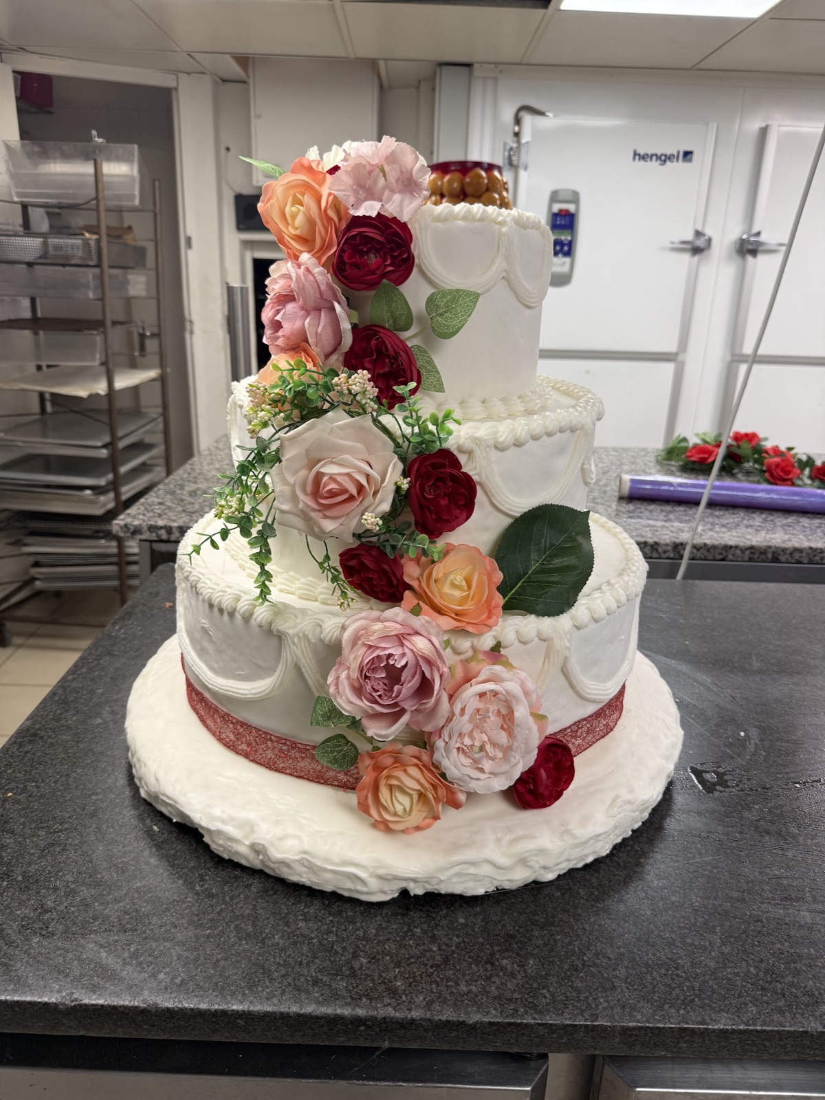 Gâteau de mariage à trois étages fleuri, réalisé sur commande