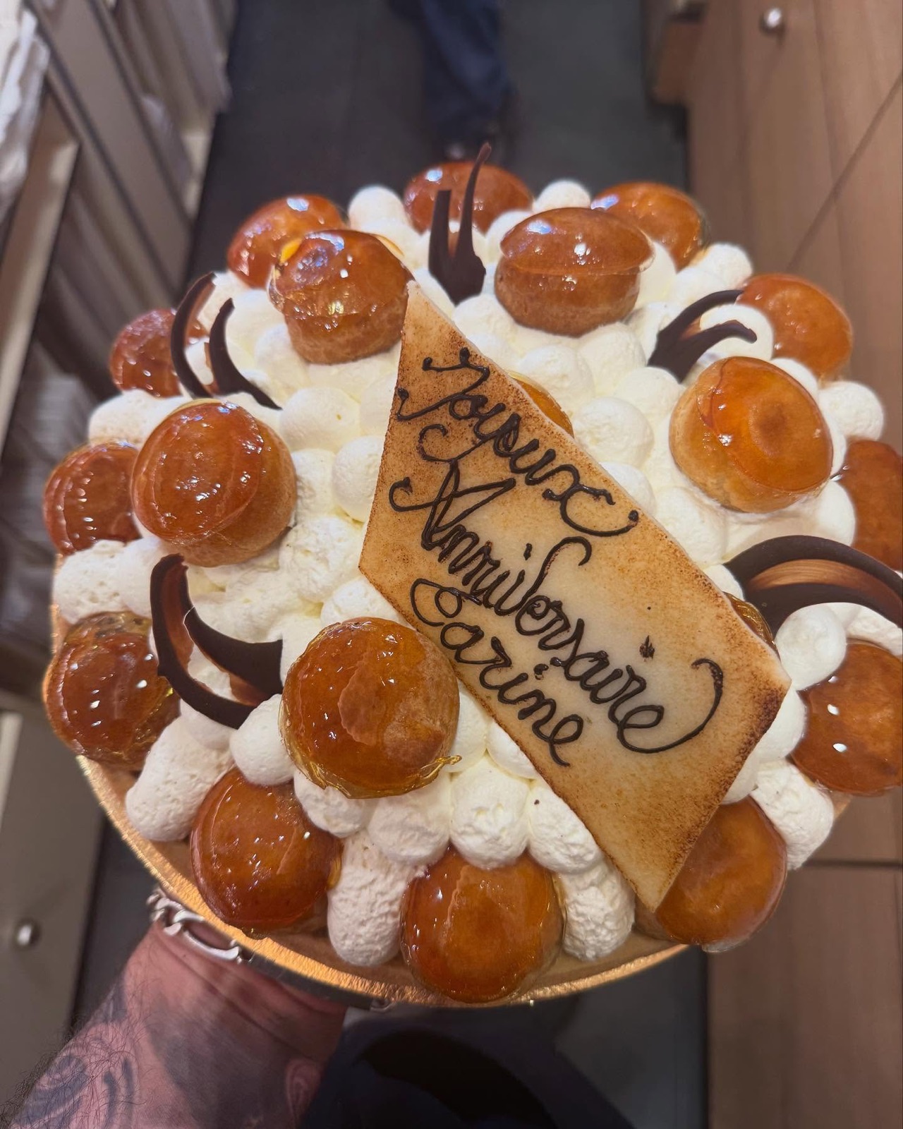 Gâteau d'anniversaire garni de choux et écriture au chocolat