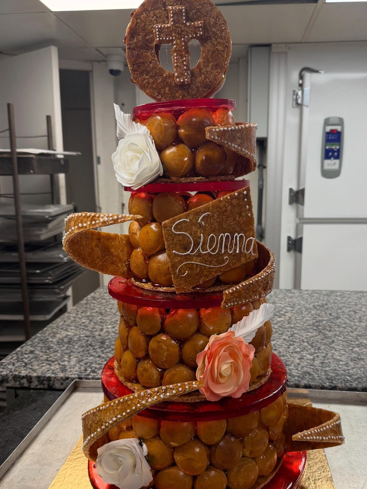 Croquembouche décoré de roses et ruban doré